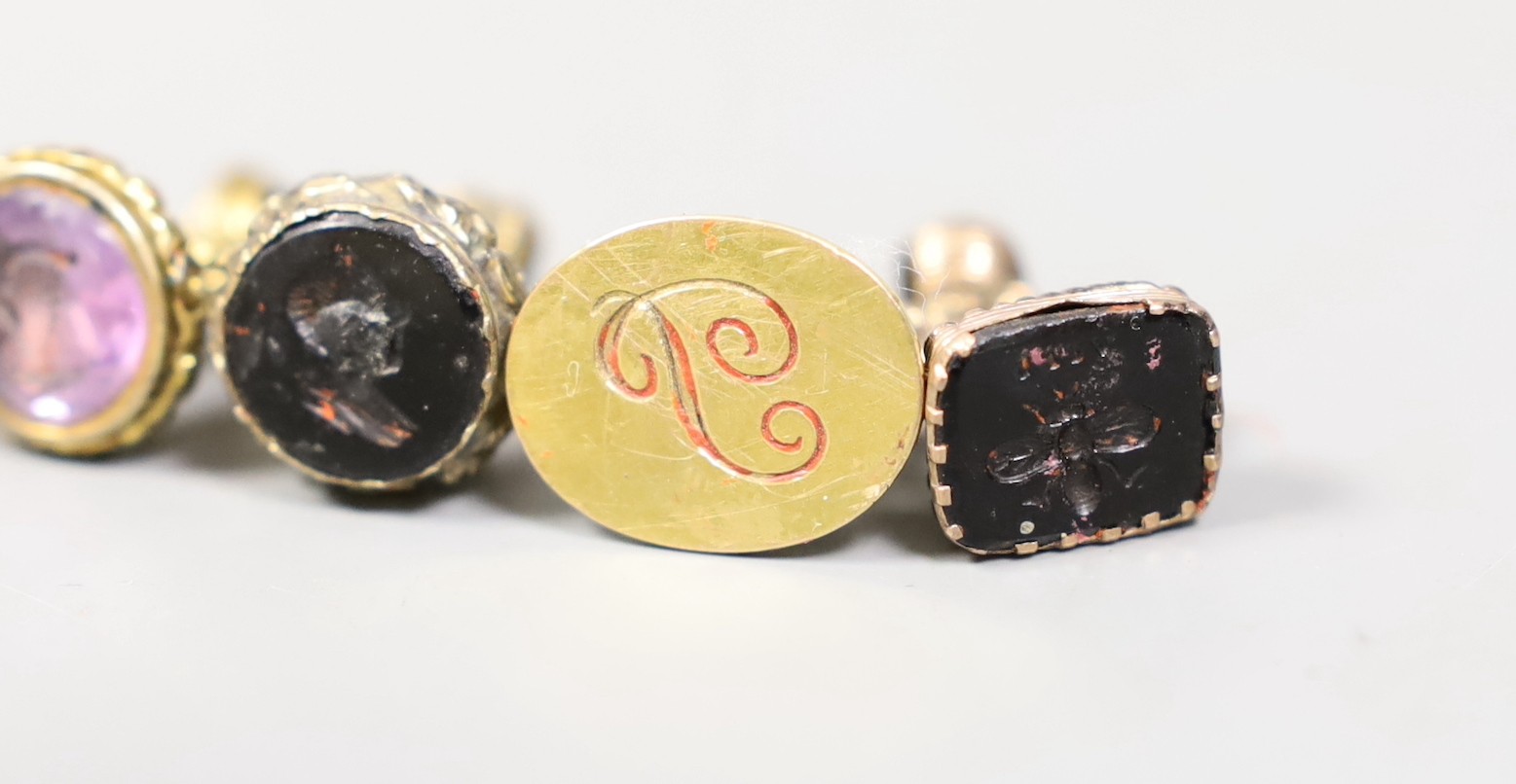 Three Victorian gilt metal fob seals, two set with bloodstone and carved with bust or bee, the other set with amethyst, a similar 9ct fob seal, a yellow metal horse head stick pin and a group of envelopes with wax seals.